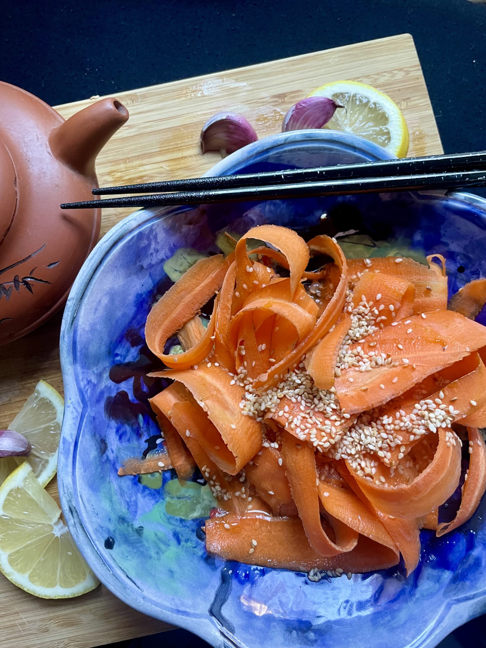 Close-up of Asian Roasted Sesame Oil Carrot Salad, showcasing vibrant, thinly sliced carrots glistening with a flavorful sesame dressing.