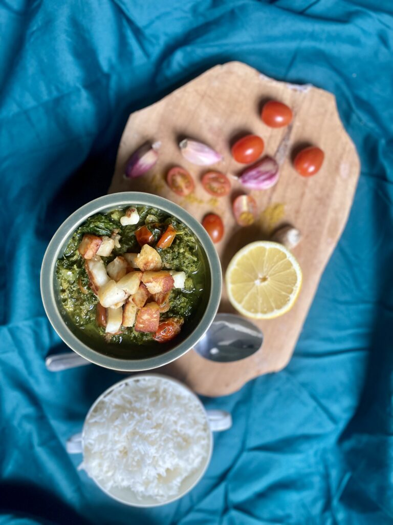 Serving of Saag Halloumi with Kale, accompanied by fluffy rice and an array of aromatic spices, creating a visually enticing and flavorful meal ready to be enjoyed.