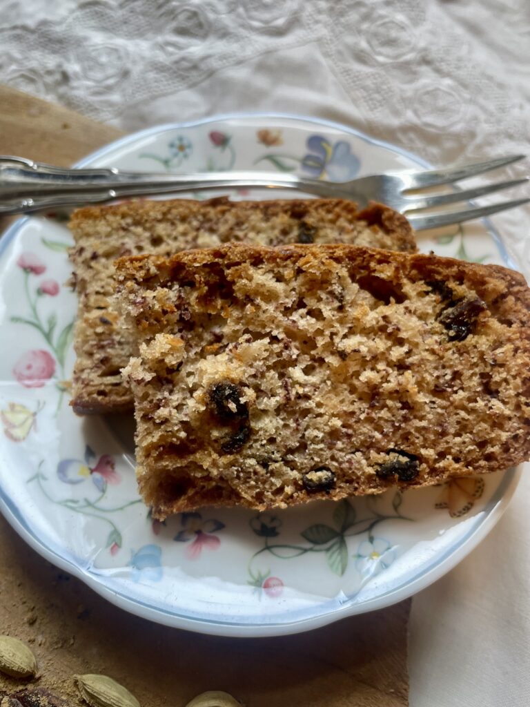 Close-up view of vegan cardamom sourdough banana bread, highlighting its moist texture, golden crust, and aromatic spices.