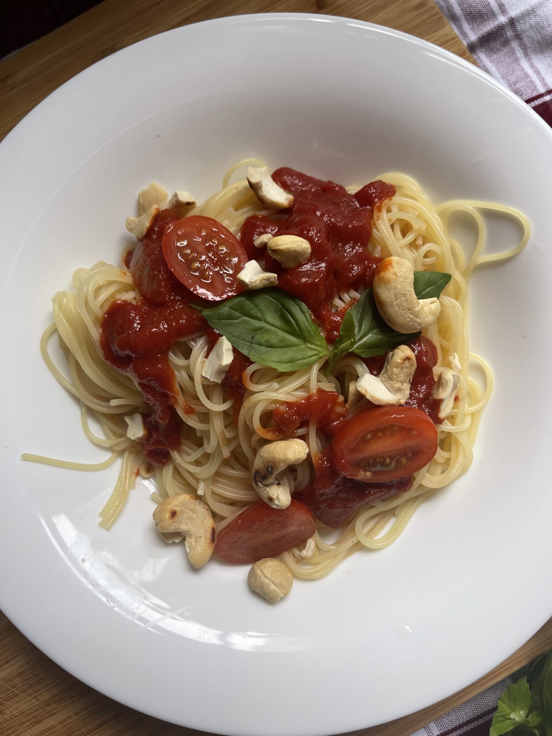 Close-up view of the mouthwatering 3-Ingredient Frugal Vegan Pasta, showcasing the rich texture of the sauce, the perfectly cooked pasta, and the vibrant colors of fresh basil and crunchy cashews. A visual feast ready to tantalize your taste buds.