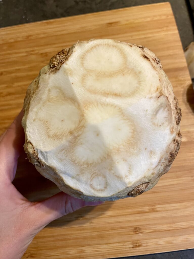 Cleaned and Trimmed Celery Root - A close-up of the celery bulb, meticulously cleaned with knobby bits removed, revealing the pristine white flesh inside. This meticulous preparation sets the stage for the delightful Asian Star Anise Roasted Celery Root (Vegan) recipe.