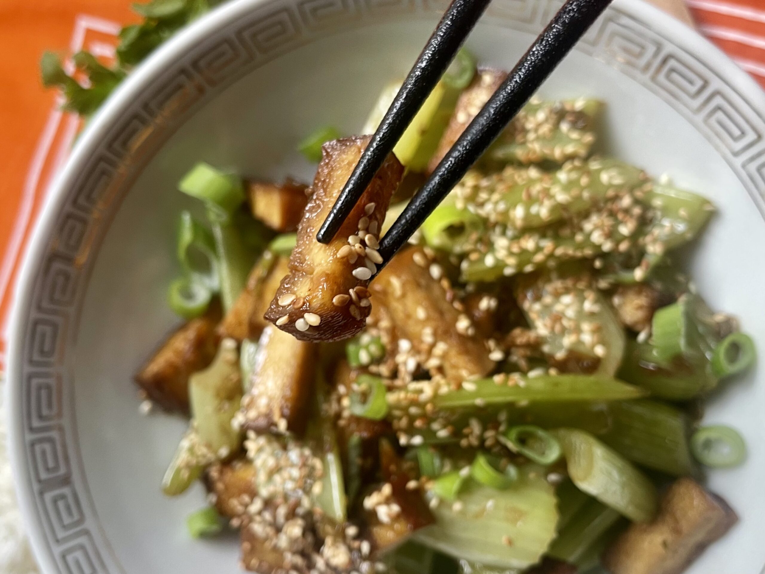 Close-up of perfectly fried and golden cubes of smoked tofu, ready to add a delightful crunch to your vegan Asian celery dish, Beijing style.