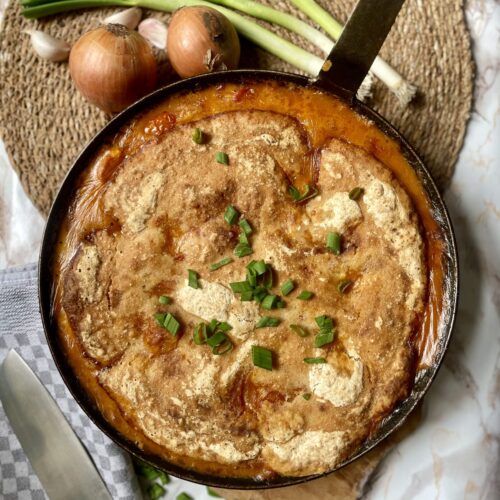 Vibrant and appetizing Spiced Dal Sourdough Skillet in a cast iron pan, showcasing a one-pot vegetarian meal with leftover dal and sourdough discard, perfect for sustainable cooking and easy tray bake meals.