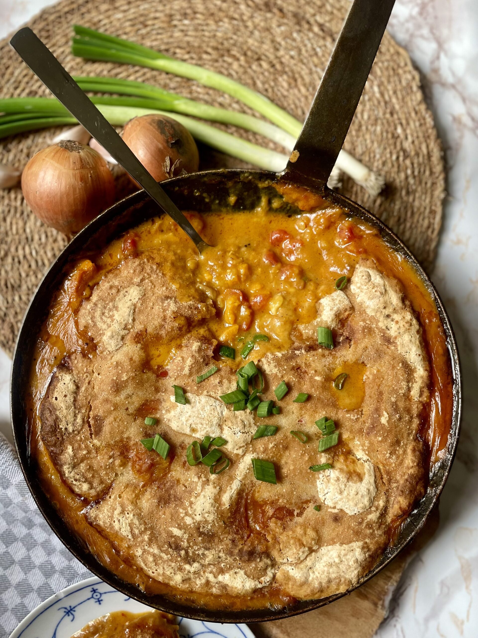 Half-eaten Spiced Dal Sourdough Skillet in a cast iron pan, showcasing the appealing textures and colors of this savory one-pot meal, demonstrating its popularity and ease of making with sourdough discard and leftover dal.